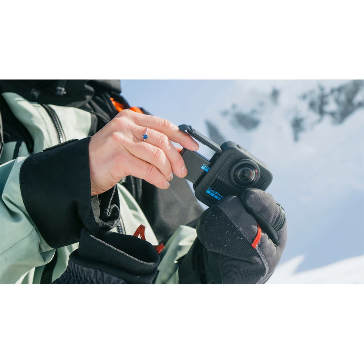  GoPro Rechargeable Enduro Battery being fitted into the MAX2 camera in cold snowy conditions.