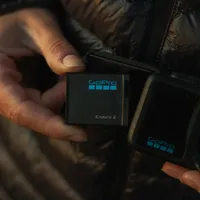 GoPro ENDURO2 Battery being inserted into a MISSION 1 camera, close-up.