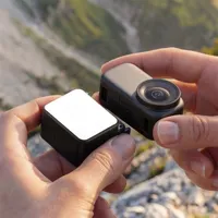 ULANZI LM24 being pressed onto the base of an Osmo Nano camera by hand, with no housing fitted.