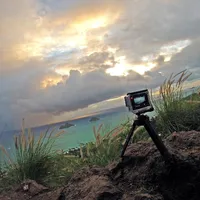 Action camera mounted on the GoPole BASE outdoors, capturing a coastal cliff view.