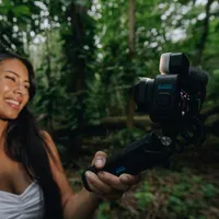 Creator filming a piece to camera in rainforest, lit by the GoPro Light Mod 2 on her GoPro.